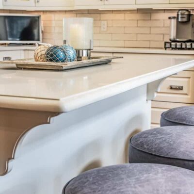 Distressed grey leather upholstered barstools by Jamie Stern
