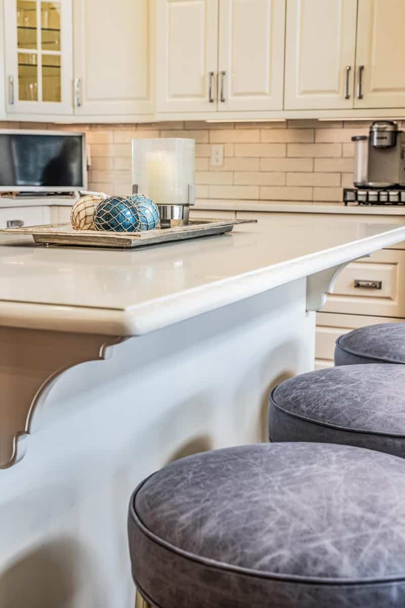 Distressed grey leather upholstered barstools by Jamie Stern